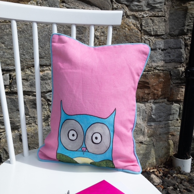 blue owl on pink oblong cushion on white chair